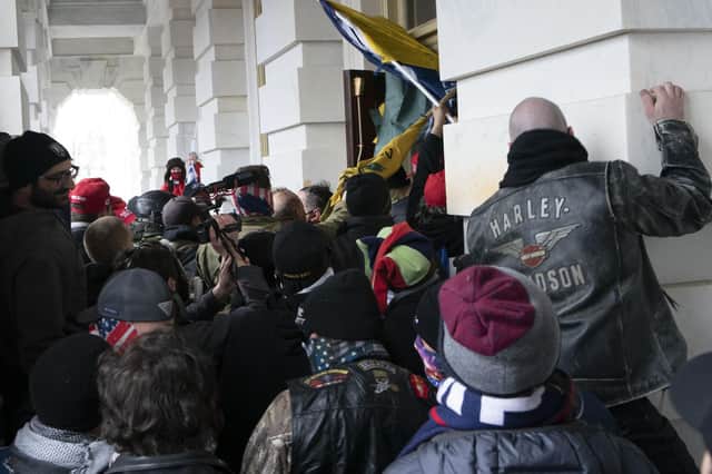 Demonstrators try to open a door of the U.S. Capitol on Wednesday, January 6, 2021, in Washington