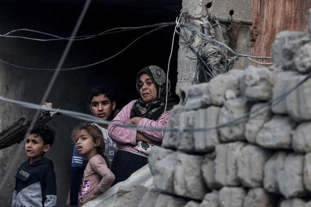 Palestinians watch from their home the transfer of the bodies of people killed in overnight bombardment earlier this week that targeted a residential area in Rafah in the southern Gaza Strip.