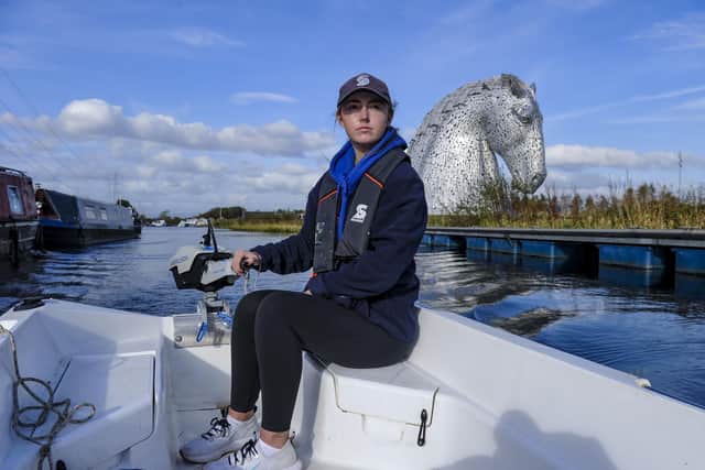 Scottish Canals activities assistant Rebecca Brown at the helm of one of its electric boats on the Forth & Clyde Canal at the Kelpies (Photo by Lisa Ferguson/The Scotsman)