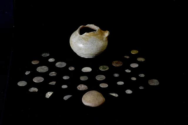 A coin hoard, pot and lid discovered during an archaeological dig in Glencoe. The coins were believed to have belonged to clan chief Alasdair Ruadh 'MacIain' MacDonald, who was a victim of Glencoe Massacre. PIC: PA.