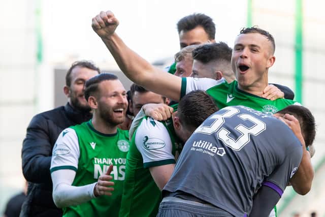 Hibs defender Ryan Porteous is mobbed by his team-mates after scoring the winning penalty.