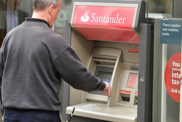 A man using a cash machine outside a branch of Santander in central London. Santander has announced it will be permanently closing 111 branches in the UK picture: John Stillwell/PA