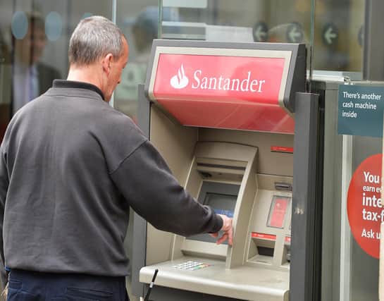 A man using a cash machine outside a branch of Santander in central London. Santander has announced it will be permanently closing 111 branches in the UK picture: John Stillwell/PA