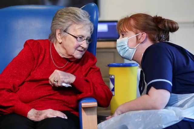 Resident Annie Innes, 90, talks with a healthcare worker after receiving the Pfizer/BioNTech Covid-19 vaccine at the Abercorn House Care Home in Hamilton.