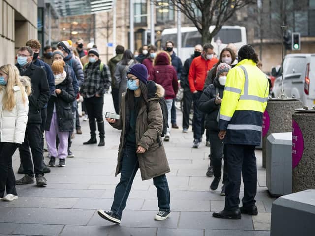 People queue outside the Edinburgh International Conference Centre (EICC) for the NHS Scotland vaccination centre as the coronavirus booster vaccination programme is ramped up to an unprecedented pace of delivery, with every eligible adult in Scotland being offered a top-up injection by the end of December. Jane Barlow/PA Wire.