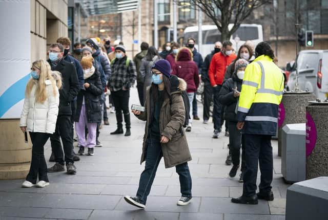 People queue outside the Edinburgh International Conference Centre (EICC) for the NHS Scotland vaccination centre as the coronavirus booster vaccination programme is ramped up to an unprecedented pace of delivery, with every eligible adult in Scotland being offered a top-up injection by the end of December. Jane Barlow/PA Wire.