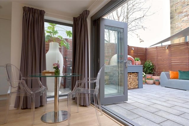 Triple bi-fold doors open from the living area to the rear patio.