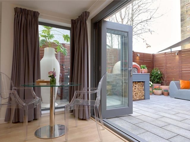 Triple bi-fold doors open from the living area to the rear patio.