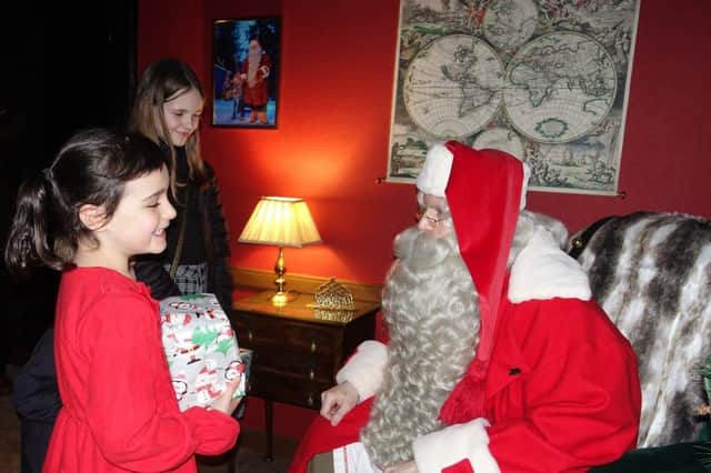 Grace Ross of Tarland is delighted to meet the Real Santa as sister Ava looks on.