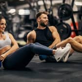 People working out in a gym lifting weights.