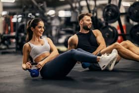 People working out in a gym lifting weights.