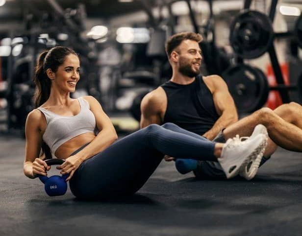 People working out in a gym lifting weights.