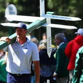 Bryson DeChambeau moves a sign while preparing to play his second shot on the 13th hole from the 14th fairway during the second round of the 2024 Masters. Picture: Photo by Maddie Meyer/Getty Images.