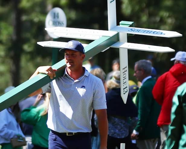 Bryson DeChambeau moves a sign while preparing to play his second shot on the 13th hole from the 14th fairway during the second round of the 2024 Masters. Picture: Photo by Maddie Meyer/Getty Images.