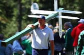 Bryson DeChambeau moves a sign while preparing to play his second shot on the 13th hole from the 14th fairway during the second round of the 2024 Masters. Picture: Photo by Maddie Meyer/Getty Images.