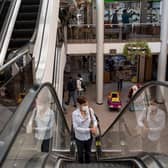 A woman use the escalator inside a shopping centre during its reopening after the outbreak of coronavirus, COVID-19, in Santiago.