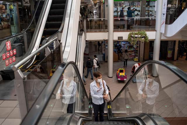 A woman use the escalator inside a shopping centre during its reopening after the outbreak of coronavirus, COVID-19, in Santiago.