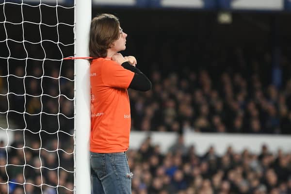 A fan ties himself to the net in protest during the Premier League match between Everton and Newcastle United at Goodison Park on March 17, 2022 in Liverpool, England. (Photo by Michael Regan/Getty Images)