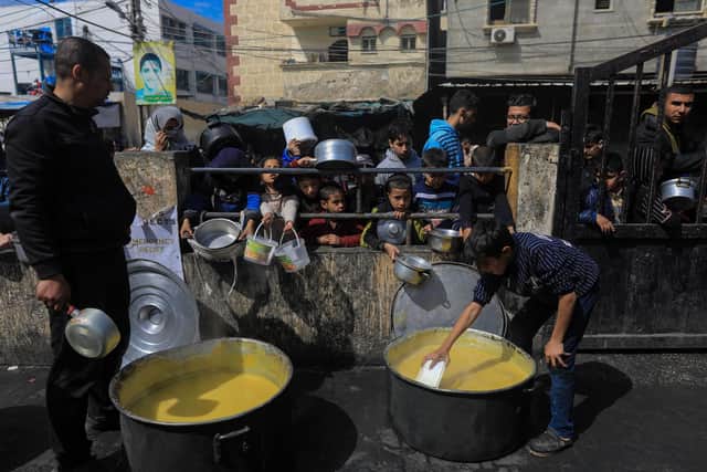 Displaced Palestinians gather to receive food in Rafah in the southern Gaza Strip amid ongoing battles between Israeli forces and Hamas fighters (Picture: Yasser Qudihe/Middle East Images/AFP via Getty Images)