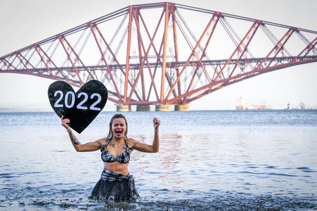 Joda Quigley, from Falkirk takes part in a New Year's Day dip in front of the Forth Bridge at South Queensferry, Edinburgh. Covid restrictions across Scotland have meant that many new year traditions including the official annual Loony Dook have been cancelled. Picture date: Saturday January 1, 2022. PA Photo. Photo credit: Jane Barlow/PA Wire