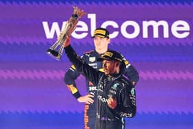 Lewis Hamilton lifts the Saudi Arabia Grand Prix trophy as second-placed Max Verstappen looks on (Photo by GIUSEPPE CACACE/AFP via Getty Images)