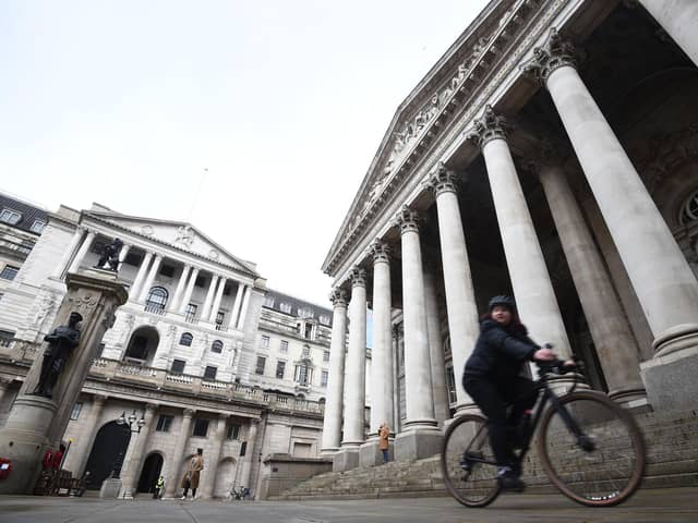 A woman cycling past the Bank of England and the Royal Exchange in the City of London. Picture: Kirsty O'Connor/PA Wire
