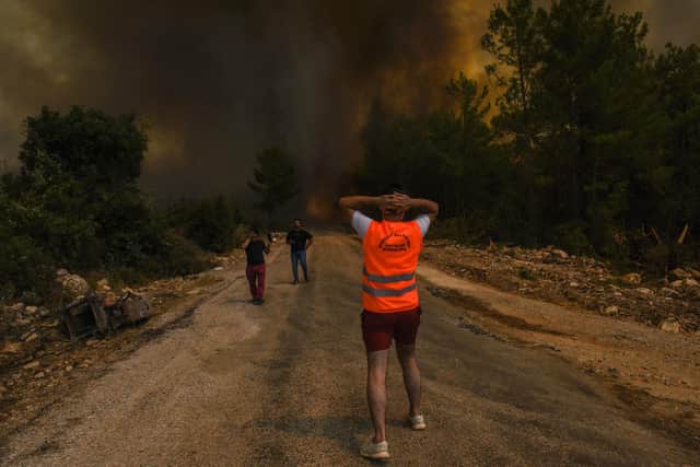 People run away from the fire-devastated Sirtkoy village, near Manavgat, Antalya, Turkey, Sunday, Aug. 1, 2021. (AP Photo)