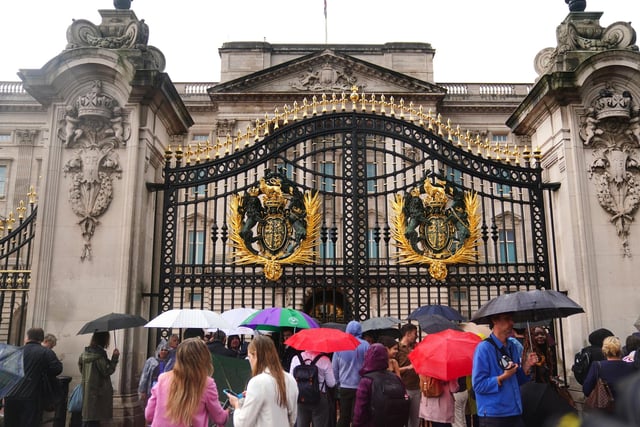 A woman laid the first bouquet at the Queen’s central London residence just after 5pm.