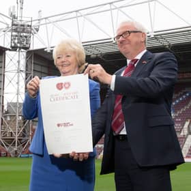 Ann Budge hands her shares to Foundation of Hearts chairman Stuart Wallace.