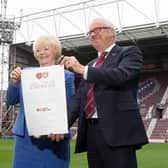 Ann Budge hands her shares to Foundation of Hearts chairman Stuart Wallace.