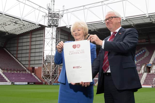 Ann Budge hands her shares to Foundation of Hearts chairman Stuart Wallace.