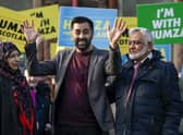 Humza Yousaf waves as he stands with his mother Shaaista and father Muzaffar during an event at Pollockshields Burgh Hall as he campaigns to become the next leader of the Scottish National Party. Photo by Jeff J Mitchell/Getty Images