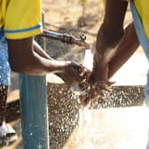 Girls wash their hands with clean water from a tap in their school, where WaterAid worked together with the community. Malawi (Picture: WaterAid/Sophie Harris-Taylor)