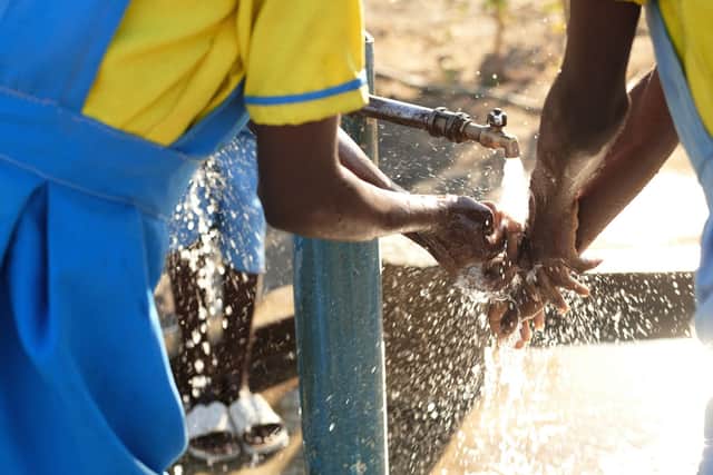 Girls wash their hands with clean water from a tap in their school, where WaterAid worked together with the community. Malawi (Picture: WaterAid/Sophie Harris-Taylor)