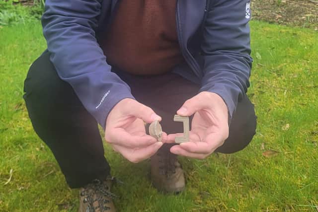 Derek Alexander, National Trust for Scotland head of archaeology, with grapeshot from the Battle of Culloden and the remains of what's believed to be a shoe belong to the Cameron chief known as 'The Gentle Lochiel'. Picture: National Trust for Scotland/PA Wire