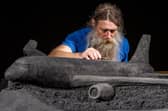 Artist Jamie Wardley working on one of his black sand sculptures commissioned by train operator LNER. Picture: Charlotte Graham