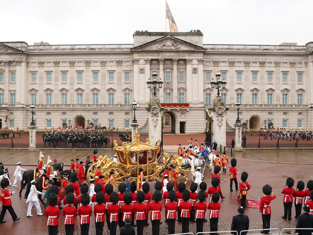 King Charles III and Queen Camilla are carried in the Gold State Coach, pulled by eight Windsor Greys, in the Coronation Procession as they return to Buckingham Palace, London, following their coronation ceremony.