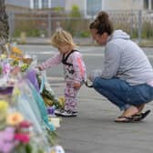 PLYMOUTH, ENGLAND - AUGUST 16: A woman and child look at the flowers and tributes left at Keyham on August 16, 2021 in Plymouth, England.  (Photo by Finnbarr Webster/Getty Images)