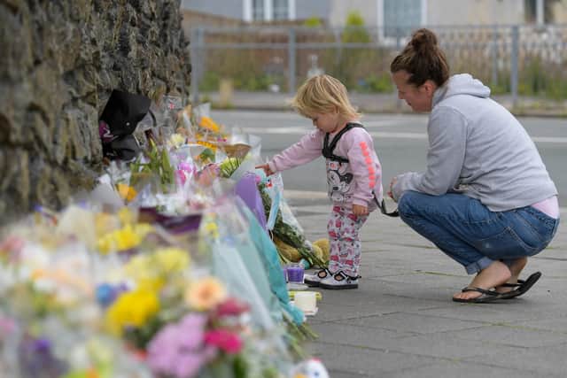 PLYMOUTH, ENGLAND - AUGUST 16: A woman and child look at the flowers and tributes left at Keyham on August 16, 2021 in Plymouth, England. (Photo by Finnbarr Webster/Getty Images)