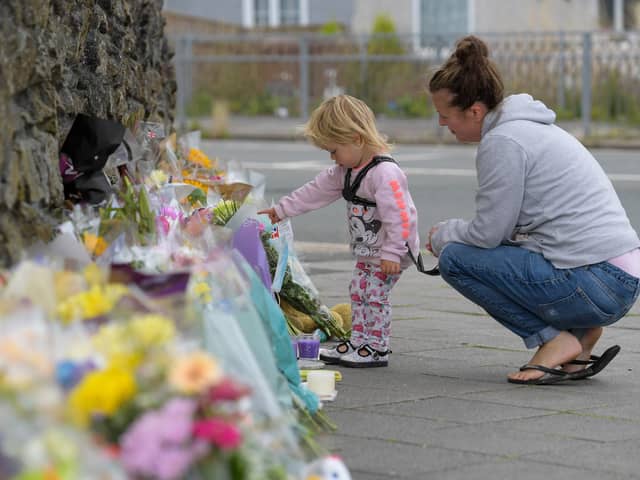 PLYMOUTH, ENGLAND - AUGUST 16: A woman and child look at the flowers and tributes left at Keyham on August 16, 2021 in Plymouth, England.  (Photo by Finnbarr Webster/Getty Images)