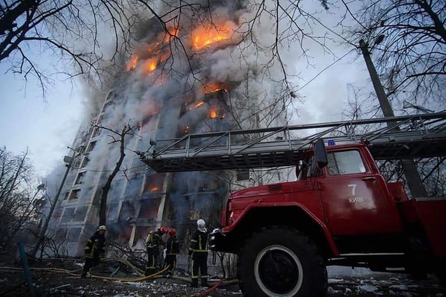 Pictured eleased by the State Emergency Service of Ukraine shows crews working to extinguish a fire in a housing block hit by shelling in the Sviatoshynsky district in western Kyiv. - Strikes on residential areas in Kyiv killed at least two people early on March 15, emergency services said, as Russian troops intensified their attacks on the Ukrainian capital. (Photo by State Emergency Service of Ukraine / AFP)