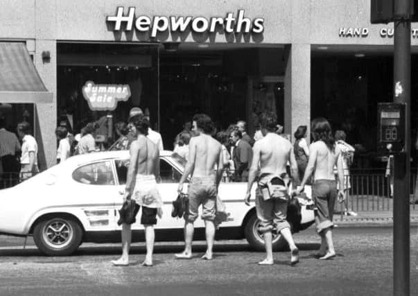 Teens stripped to the waist and in bare feet crossing Princes Street in summer 1976.