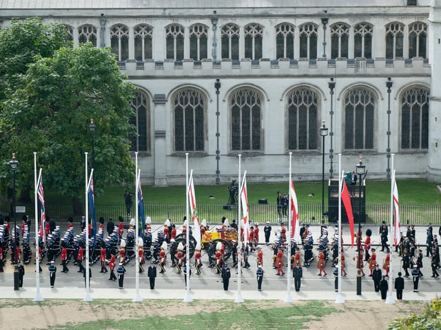 The State Gun Carriage carries the coffin of Queen Elizabeth II, draped in the Royal Standard with the Imperial State Crown and the Sovereign's orb and sceptre, as it leaves Westminster Abbey after the State Funeral of the Queen. Picture date: Monday September 19, 2022.