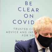 Boris Johnson prepares to watch a man receive his Covid booster jab in a Boots pharmacy in his Uxbridge constituency (Picture: Leon Neal/Getty Images)