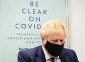 Boris Johnson prepares to watch a man receive his Covid booster jab in a Boots pharmacy in his Uxbridge constituency (Picture: Leon Neal/Getty Images)