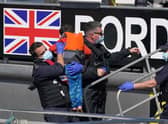 Border Force officers help a young child brought in to Dover, Kent, with a group of people thought to be migrants following a small boat incident in the Channel, September 8, 2021. Picture: Press Association