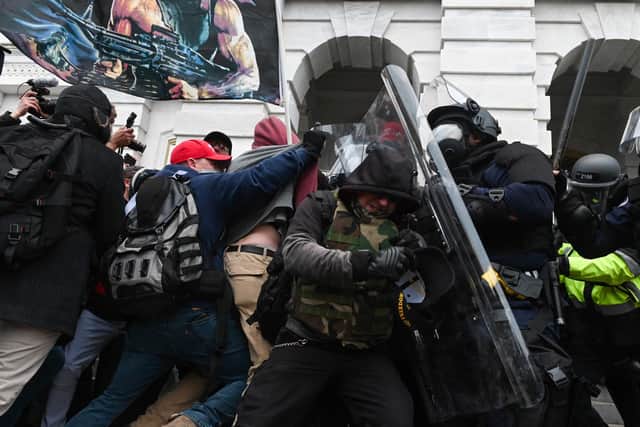 Riot police push back a crowd of Trump supporters after they stormed the Capitol building in Washington, DC (Picture: Roberto Schmidt/AFP via Getty Images)