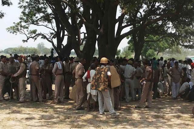 An angry crowd at the tree in Uttar Pradesh where the teenage sisters were found hanged after both were reportedly abducted and raped