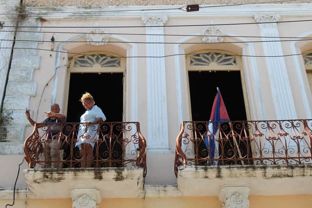 Local residents watching the FIDANZ procession from their balcony, Calle Enramadas, Santiago de Cuba. Pic: Caledonia Worldwide
