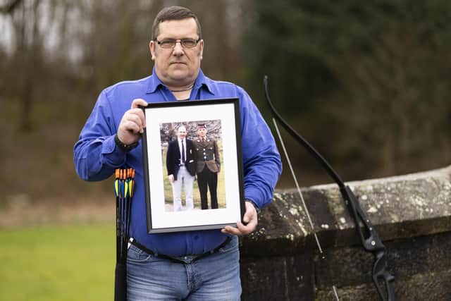 Alan Kennedy at the Erskine Home in Bishopton, Renfrewshire, holding a picture of himself in the Royal Scots army with his father. Picture: PA